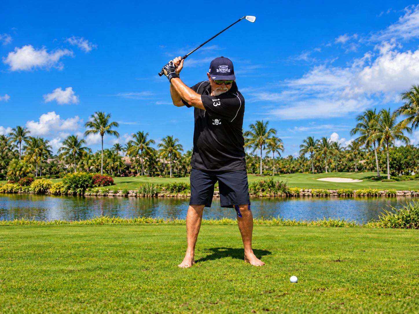 John playing barefoot golf beside a palm-lined lake